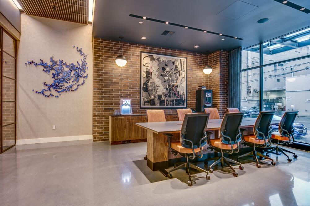 High ceilings, floor-to-ceiling windows, and exposed brick in conference room at 970 Denny
